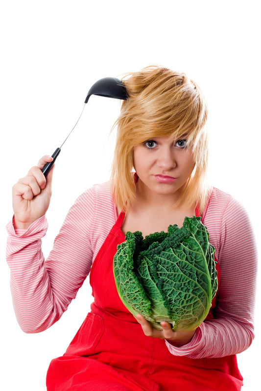 A woman in an apron holding a head of cabbage