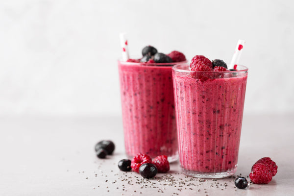 2 glasses of raspberry and blueberry smoothies with collagen powder to help your skin naturally glow