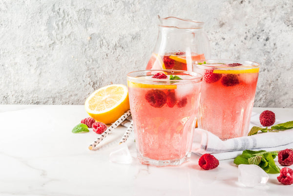 Glasses of water naturally flavoured with raspberries to make it taste better