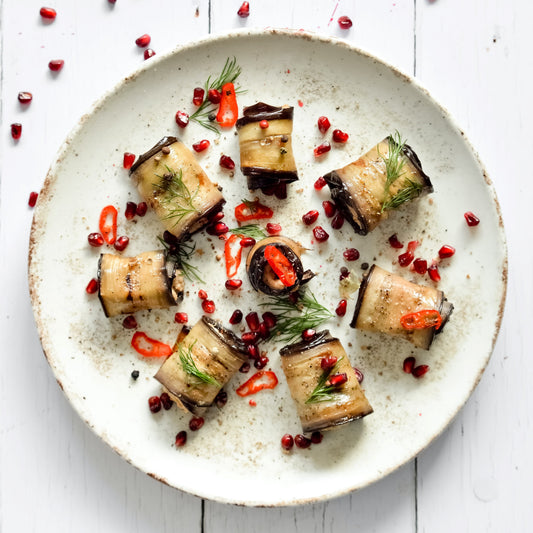 Roasted aubergines rolls with pomegranate and herbs