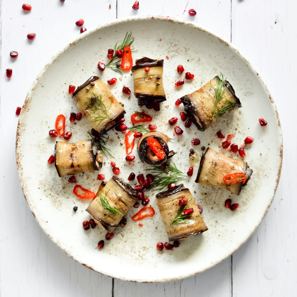 Roasted aubergines rolls with pomegranate and herbs