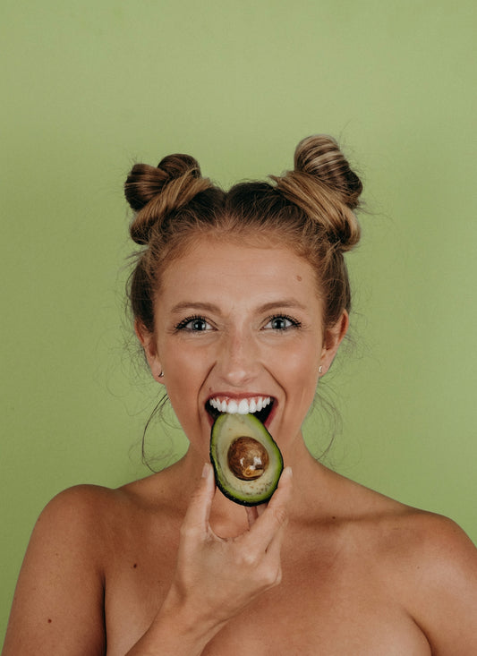 woman holding sliced avocado