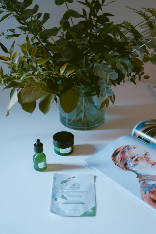 plants in clear vase near open magazine