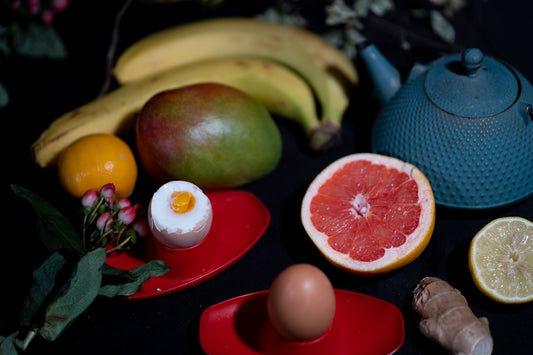 green apple fruit beside red round fruit on red ceramic plate