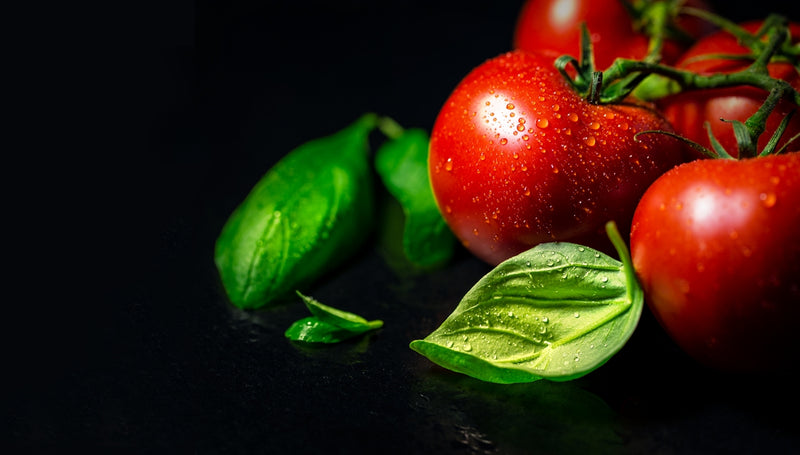 red tomato beside green leaves