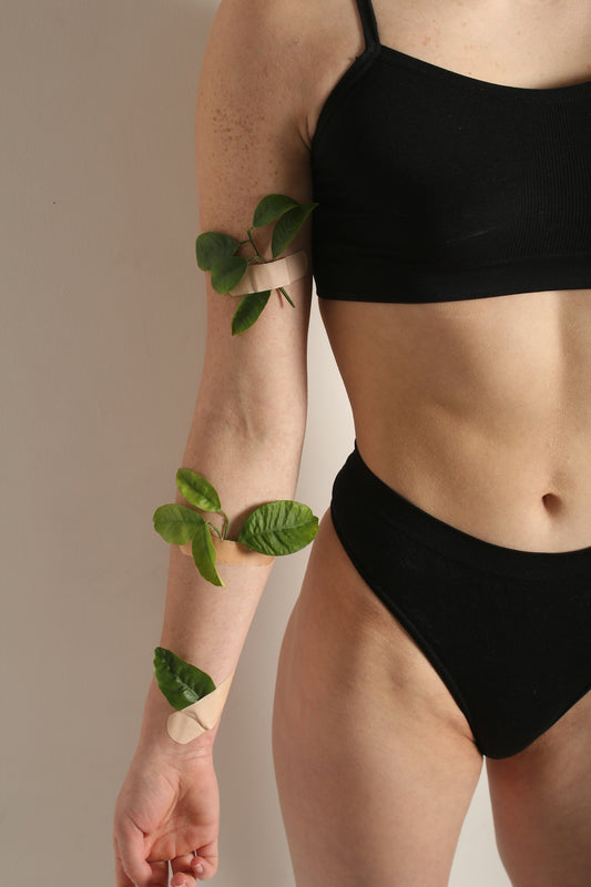 a woman in a black bikini holding a green plant