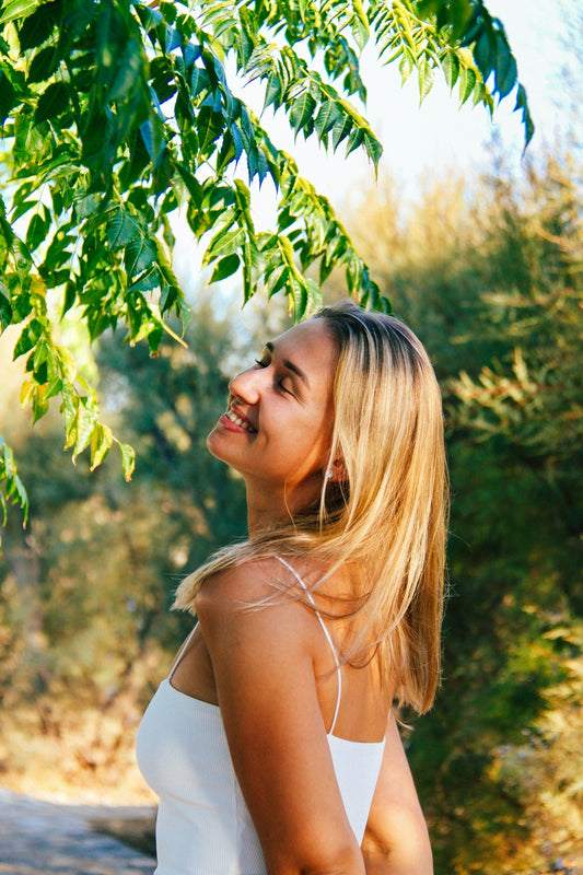 a woman smiling under a tree