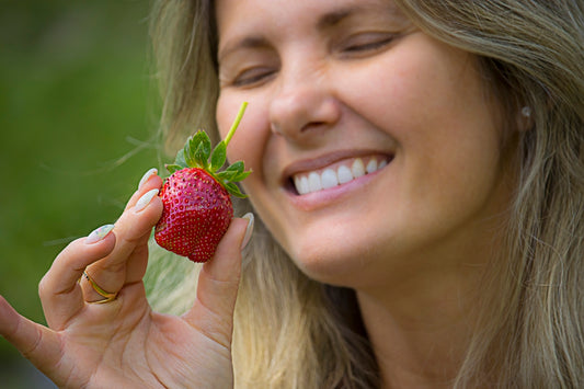 a woman holding a strawberry