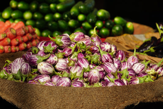 a pile of purple and green onions sitting on top of a table