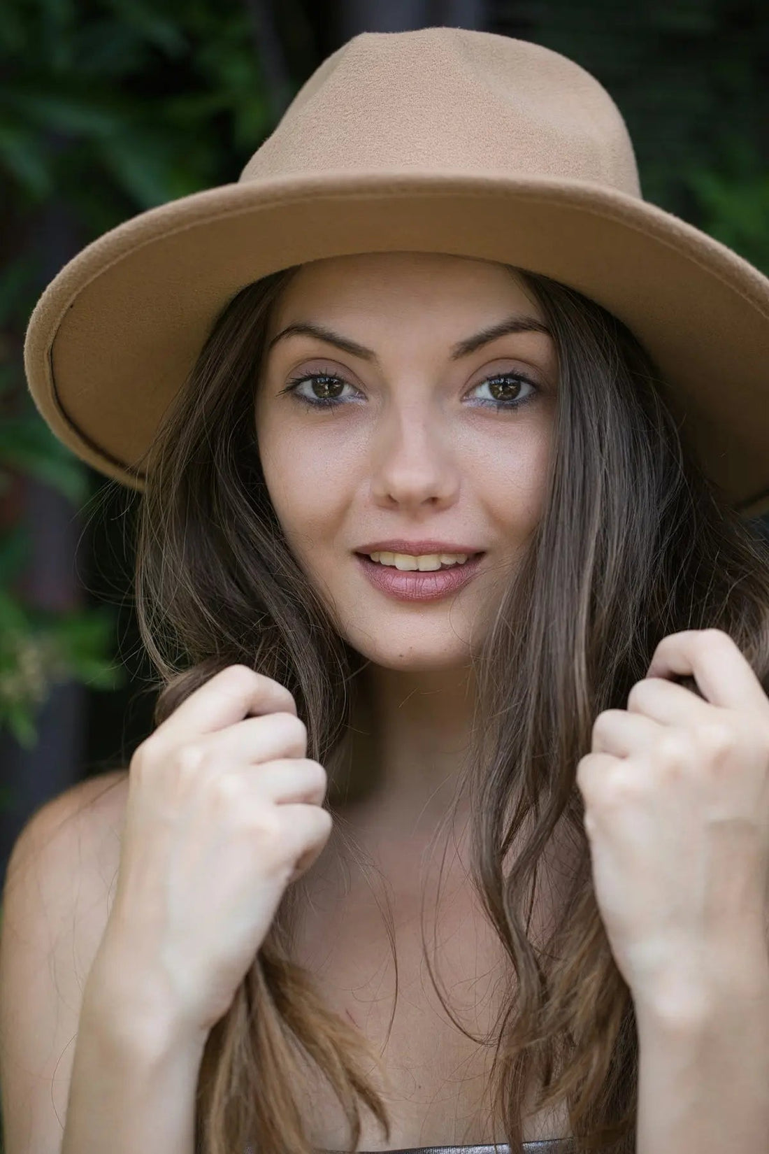 A woman wearing a tan hat posing for a picture