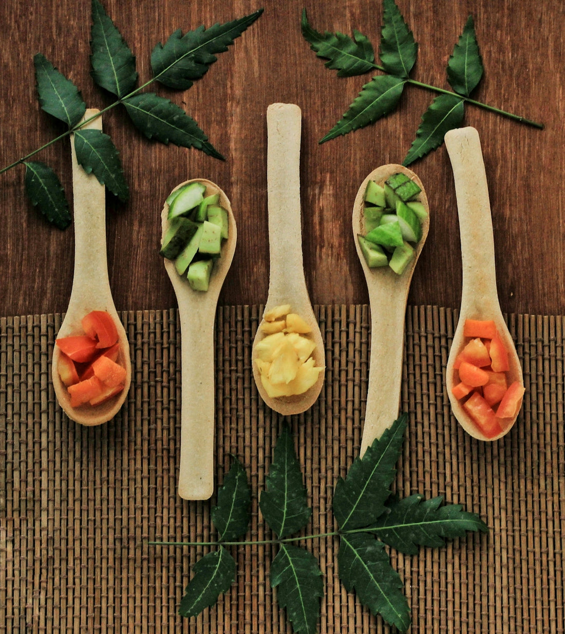 Five wooden spoons filled with different types of food