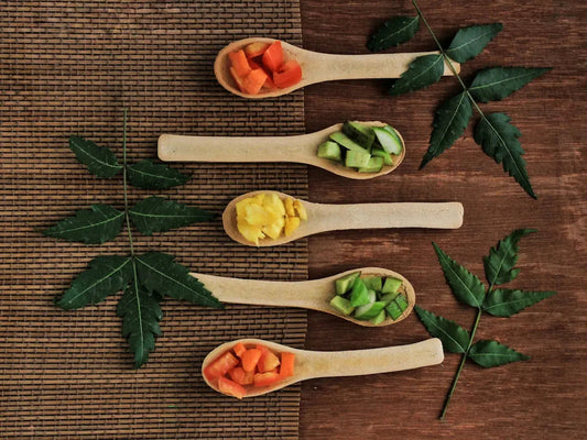 Five wooden spoons filled with different types of vegetables