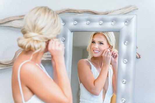 A woman standing in front of a mirror brushing her teeth