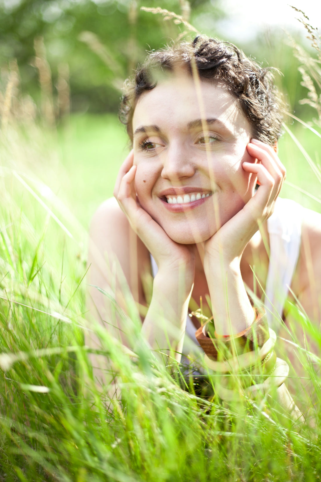 A woman laying in a field of tall grass