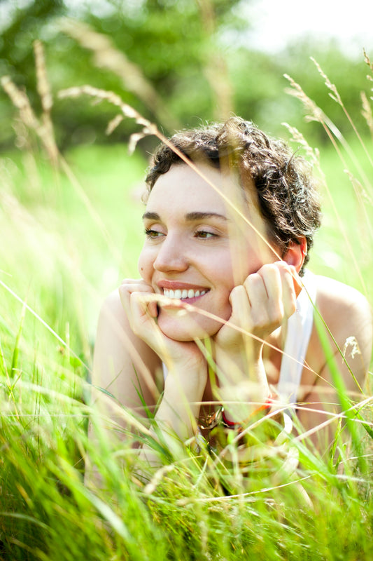 A woman laying in a field of tall grass