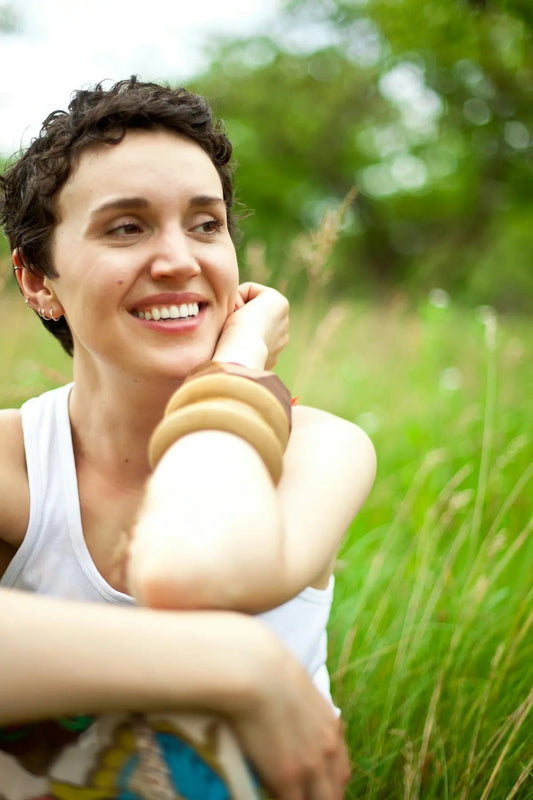 A woman sitting in a field of tall grass