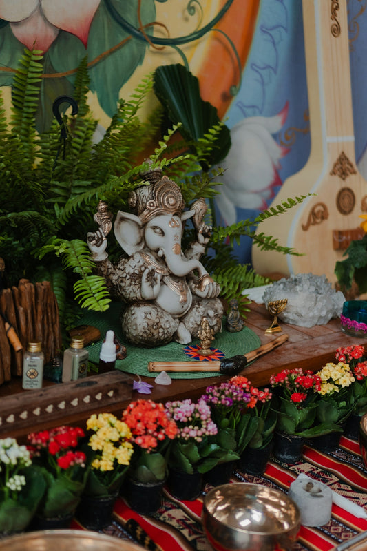 Ganesha statue surrounded by plants and flowers