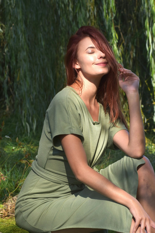 Woman with red hair in a green dress outdoors