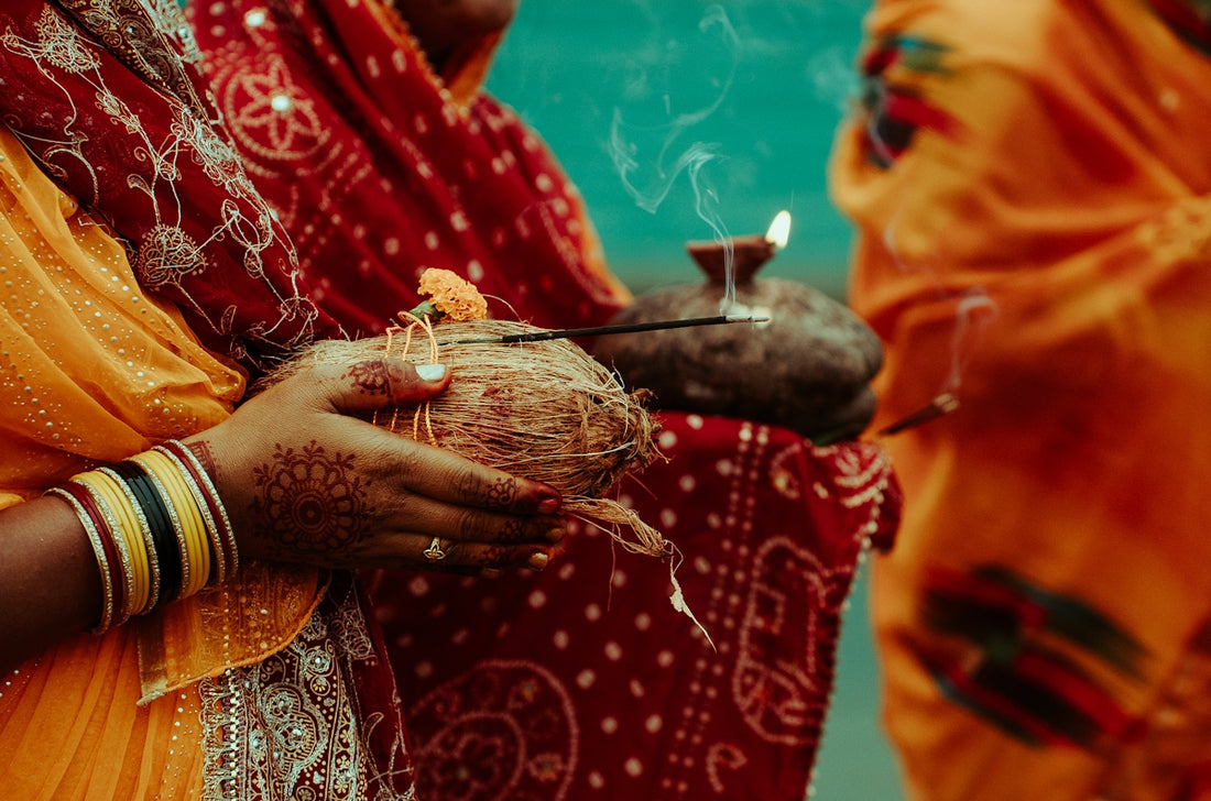 Woman holding coconut and incense during a religious ceremony
