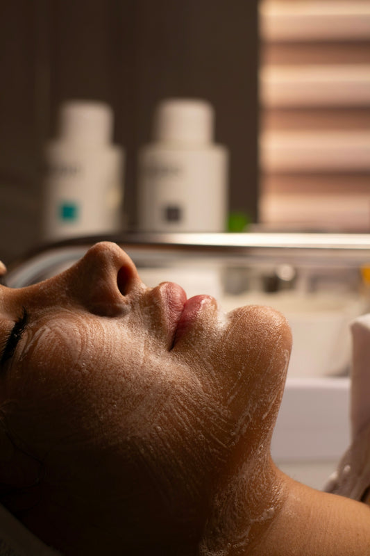 Woman's face with cleansing foam during facial treatment.