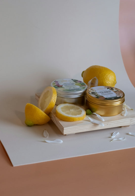Two tins with lemons and petals on a wooden board