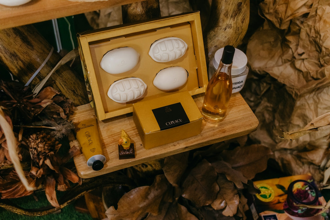 A wooden tray displays natural soaps, oil, and cosmetic products.