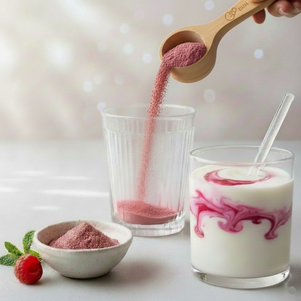 A wooden scoop pouring a pink vegan collagen peptides blend into a glass