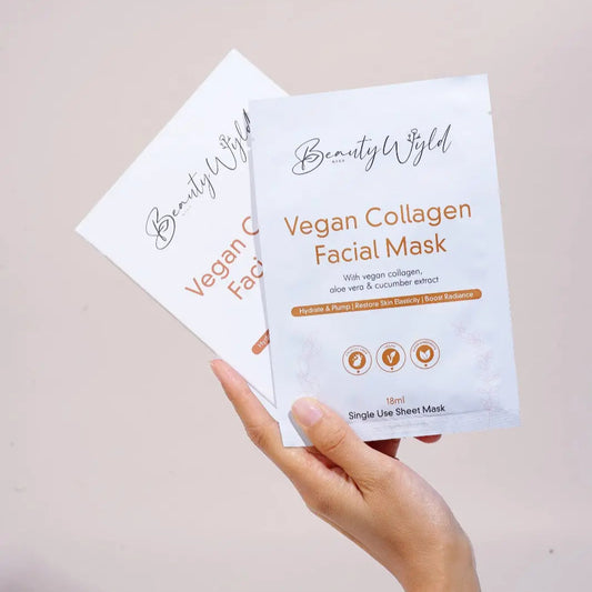 A woman's hand holding a box and a packet of vegan collagen face masks by Raw Beauty Labs Beauty & The Wyld Collection