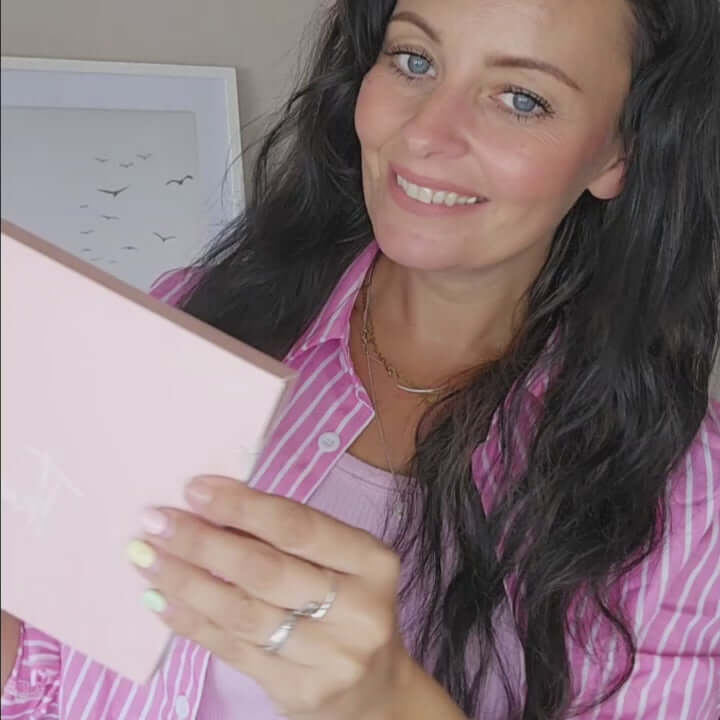 Smiling customer unboxing Vegan Collagen Superfood pink pouch